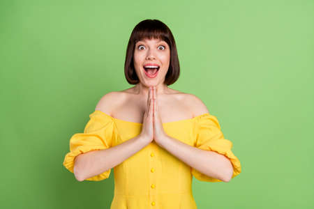 Photo of amazed shocked young attractive young woman clap hands wait gift isolated on green color backgroundの写真素材