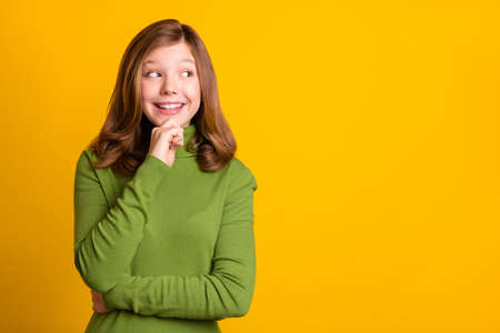 Photo portrait young girl smiling touching chin thoughtful looking copyspace isolated vibrant green color backgroundの写真素材