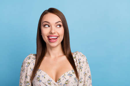 Photo of pretty brunette hairdo young lady look empty space tongue out wear floral blouse isolated...