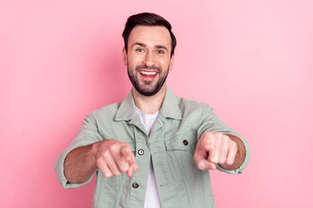 Photo of nice optimistic brunet man point you wear grey shirt isolated on pastel pink color backgroundの写真素材