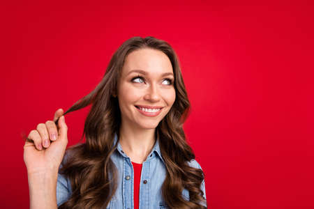 Portrait of attractive dreamy cute cheerful girl thinking creating solution isolated over vibrant red color backgroundの写真素材