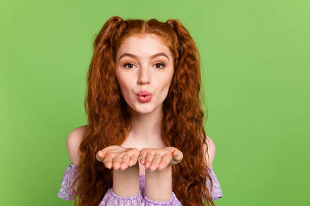 Photo of flirty orange hairstyle young lady blow kiss wear blouse isolated on green color backgroundの写真素材