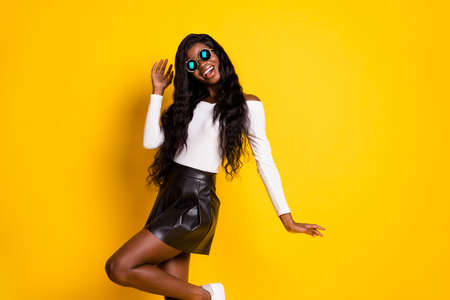 Photo portrait of funky girl wearing sunglass smiling in stylish outfit isolated vivid yellow color backgroundの写真素材