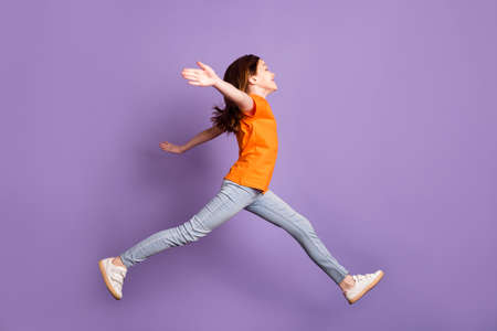 Full length body size profile side view of nice cheerful girl jumping walking hugging isolated over violet purple color backgroundの写真素材