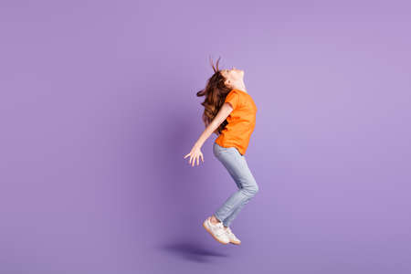 Full length body size view of attractive spprty girl jumping having fun dancing isolated over violet purple color backgroundの写真素材