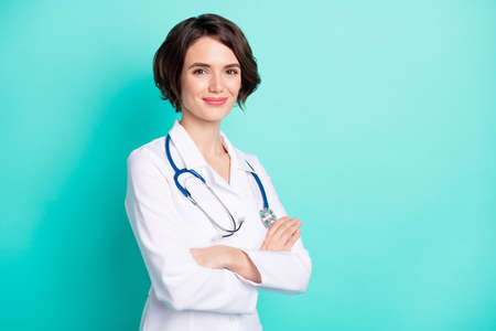Profile side photo of young woman happy positive smile crossed hands surgeon hospital disease isolated over teal color backgroundの写真素材