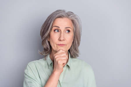 Photo of thoughtful minded serious mature woman look copyspace thinking dreaming isolated on grey color backgroundの写真素材