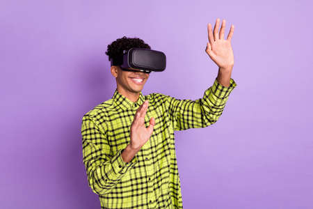 Photo portrait of guy wearing virtual reality glasses playing game laughing happy isolated on pastel violet color backgroundの写真素材