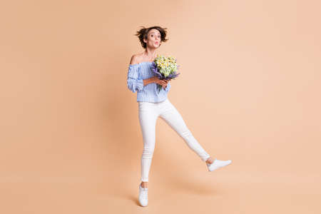 Full body photo of young excited girl amazed surprised receive flowers bouquet jump up isolated over...