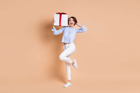 Full length photo of young girl amazed shocked surprised present gift happy smile isolated over...