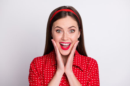 Photo of excited dreamy girl open mouth hands cheeks wear red dotted vintage blouse isolated grey color backgroundの写真素材