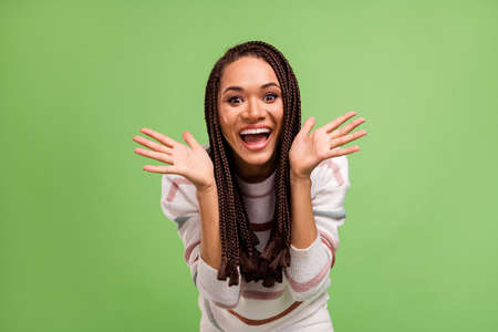 Photo of cheerful amazed afro american young woman raise hands smile isolated on green color...