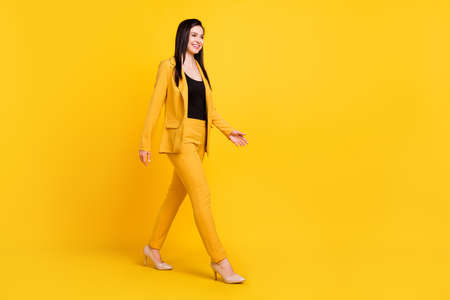Full size profile photo of nice young work lady go wear yellow blazer trousers isolated on vivid color backgroundの写真素材