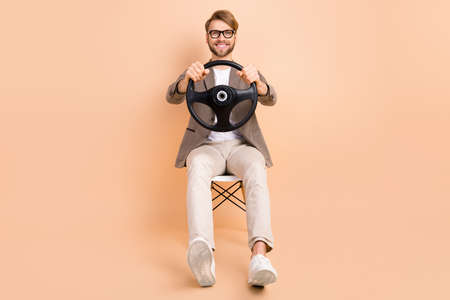 Full size photo of happy positive good mood handsome man riding car hold steering wheel isolated on...