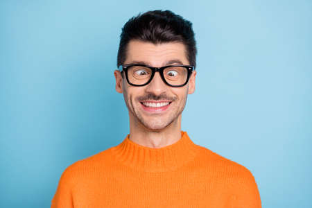 Portrait of young person wear glasses squint eyes toothy smile have fun wear pullover isolated on blue color backgroundの写真素材