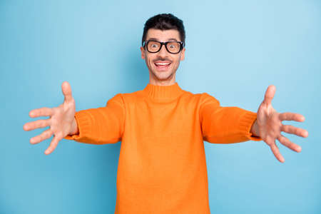 Photo of young handsome man happy positive smile cheerful want to hug you isolated over blue color...