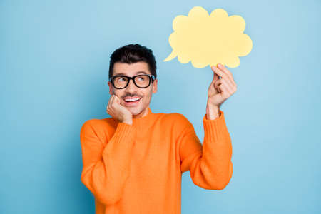 Photo of young cheerful man happy positive smile think dream dreamy look paper cloud isolated over blue color backgroundの写真素材