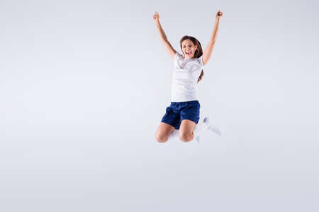 Full length body size view of nice attractive lovely crazy energetic overjoyed cheerful cheery straight-haired girl jumping having fun rejoicing isolated on light white gray pastel color backgroundの写真素材