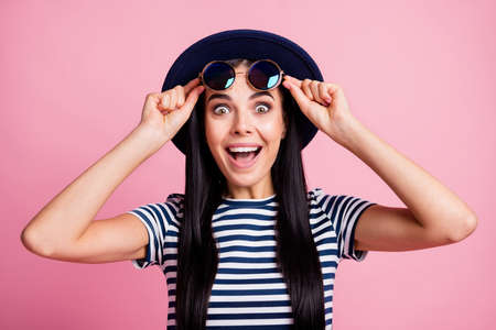 Photo portrait of impressed woman taking off pulling up glasses isolated on pastel pink colored...
