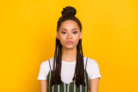 Photo of serious young dark skin woman calm peaceful face dreadlocks hair isolated on yellow color...