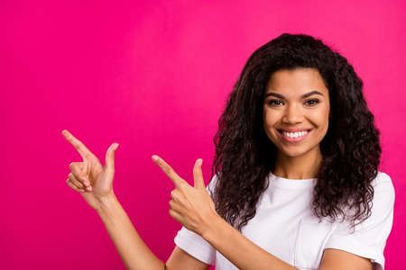 Photo of sweet brunette millennial lady point empty space wear white t-shirt isolated on vivid pink color backgroundの写真素材