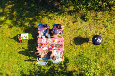 High above angle view friends spending free time cooking barbeque outside drinking beer having...