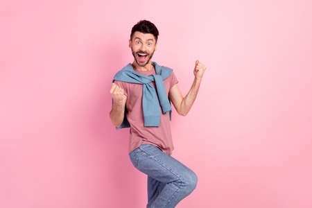 Photo of happy excited crazy smiling good mood man raise fists in victory success isolated on pink color backgroundの写真素材