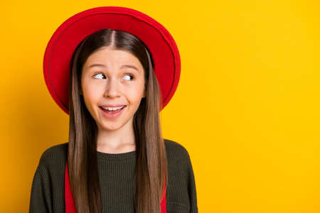 Close-up portrait of attractive cheerful funny curious girl looking aside thinking copy space isolated over bright yellow color backgroundの写真素材