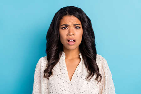 Photo of young unhappy upset shocked amazed afro girl having problems troubles isolated on blue...