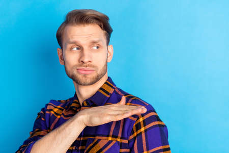 Photo of young man arm palm look interested empty space wear plaid isolated on blue color background