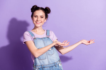 Photo of pretty sweet young woman dressed denim overall inviting you come empty space isolated purple color backgroundの写真素材