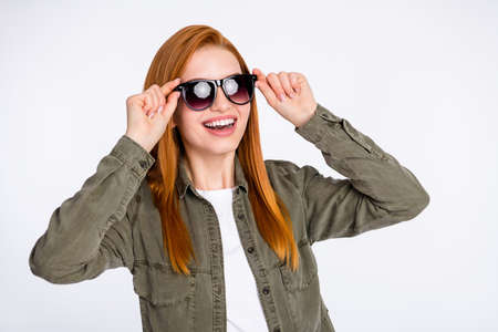 Portrait of attractive cheerful dreamy red haired girl touching specs having fun isolated over white light color backgroundの写真素材