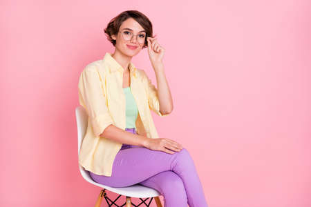 Photo of pretty charming young woman wear yellow shirt arm glasses sitting chair empty space...