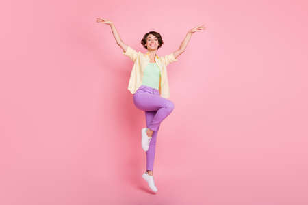 Full size photo of optimistic brunette lady jump wear shirt trousers sneakers isolated on pastel pink color backgroundの写真素材
