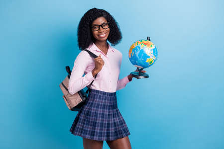 Photo of young cheerful black girl happy smile hold globe geography lesson study homework isolated over blue color backgroundの写真素材