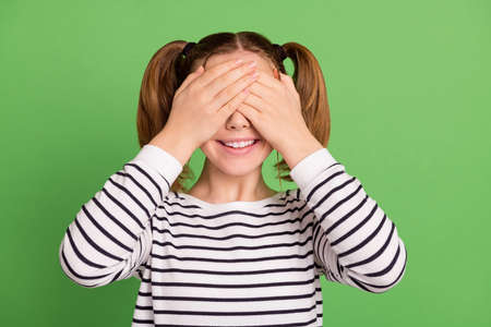 Photo of funny tails hairdo little girl close eyes wear striped sweater isolated on green color backgroundの写真素材