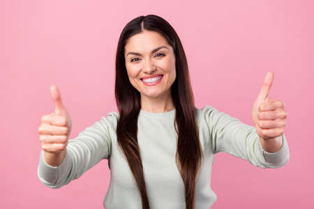 Photo of charming positive nice young woman show thumbs up promoter sale isolated on pink color backgroundの写真素材
