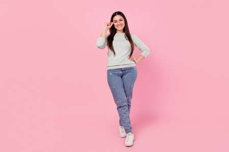 Full body photo of happy nice cheerful young woman hold hand waist wear glasses isolated on pink color backgroundの写真素材