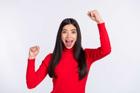 Photo of funny astonished brown long hairdo lady hands fists wear red cloth isolated on grey color backgroundの写真素材