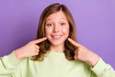 Photo of young cheerful girl happy positive smile point fingers teeth stomatology isolated over...