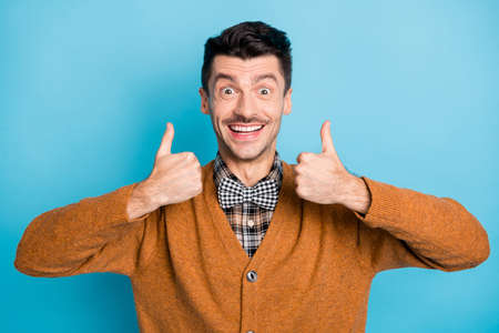 Photo of cheerful person beaming smile show two arms thumbs up have good mood isolated on blue color...