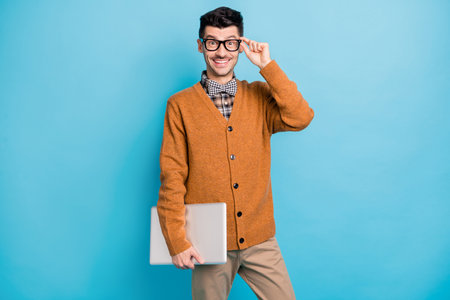 Photo of funny cute young man hand wear brown cardigan arm spectacles holding modern gadget isolated...