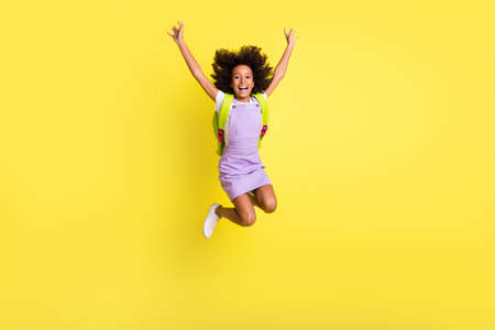 Full length body size photo of funny schoolgirl jumping high with rucksack laughing careless...