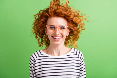 Photo of funny adorable young lady dressed striped clothes glasses smiling wind blowing isolated...