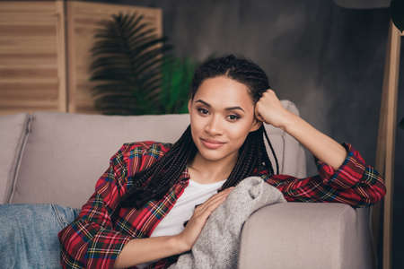 Portrait of attractive cheery girl lying on sofa resting spending spare time pastime weekend at...