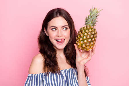 Photo of adorable sweet lady wear off-shoulders clothes licking lips holding pineapple empty space...