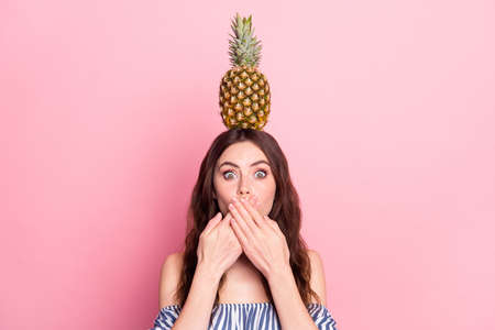 Photo of guilty shocked young woman dressed striped outfit holding head fruit arms cover lips isolated pink color backgroundの写真素材