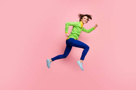 Full size profile side photo of young girl happy positive smile run jump speed hurry sale isolated over pastel color backgroundの写真素材