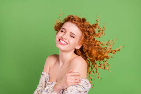 Photo of beautiful young happy positive lady wind blow air spring isolated on green color backgroundの写真素材