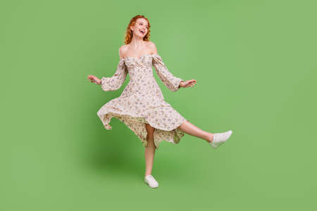 Full body photo of positive funky young woman good mood dance fly skirt isolated on green color...